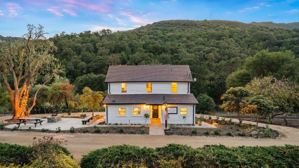 a white house with a mountain in the background at 8 Mile House by AvantStay in Santa Margarita