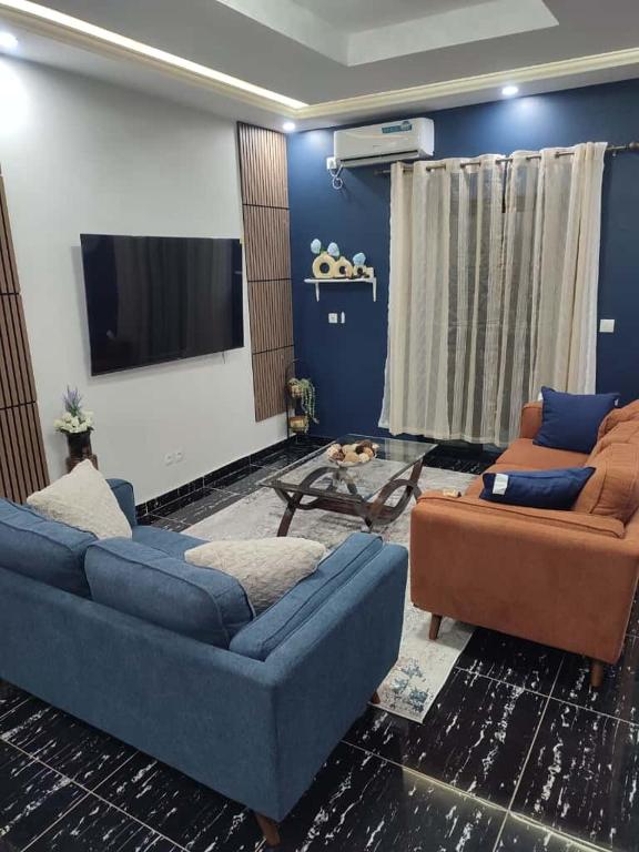 a living room with two couches and a flat screen tv at Tam-Toboyah in Conakry