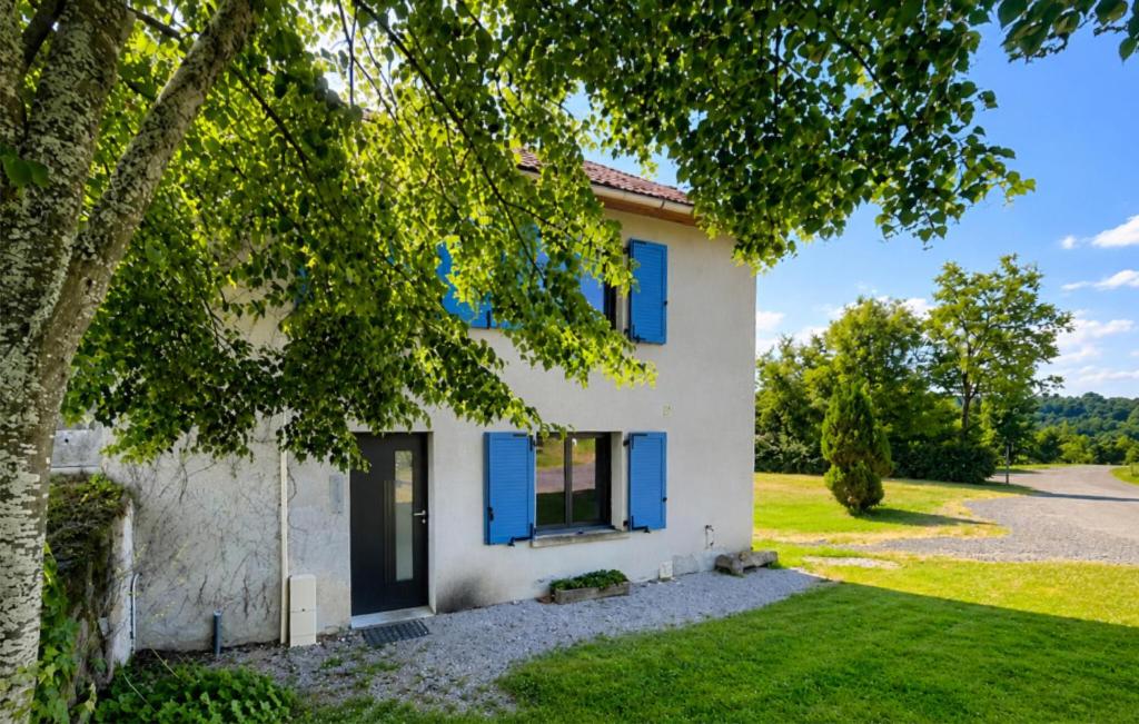 a house with blue shutters and a tree at 2 Bedroom Cozy Home In Beaulieu in Beaulieu