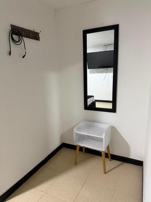 a mirror and a stool in a room at Hotel Nexo in Medellín