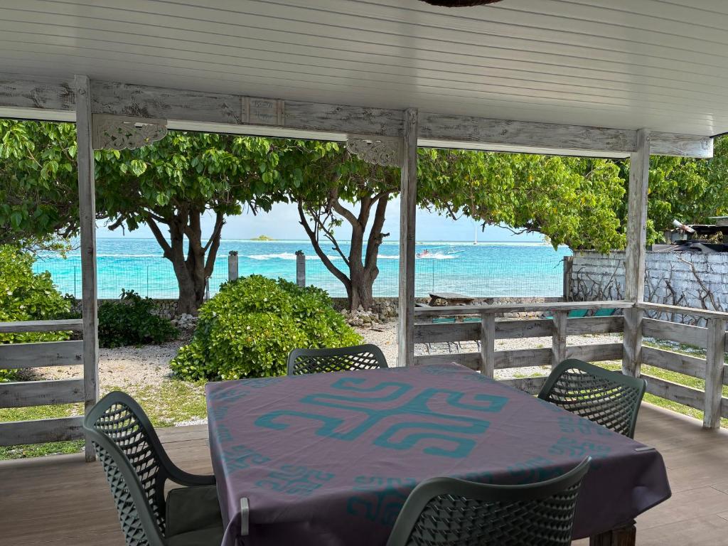 a table and chairs with the ocean in the background at Faré Pépénai in Avatoru