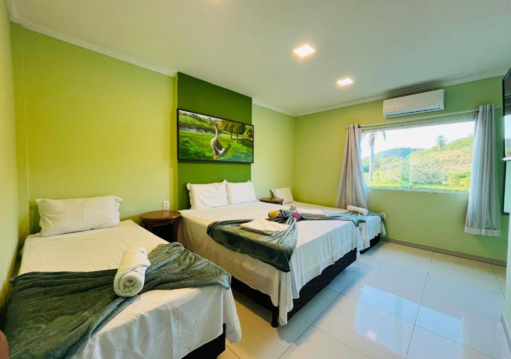 a hotel room with two beds and a window at Hotel Fazenda Oásis in Carpina