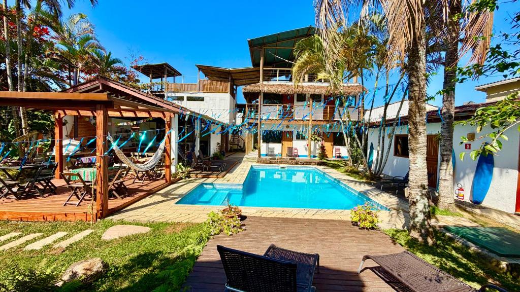 a house with a swimming pool next to a building at Makai Suites in Ubatuba