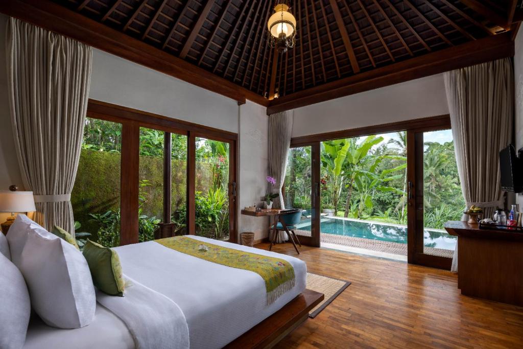a bedroom with a bed and a pool at Nau Villa Ubud in Tegalalang