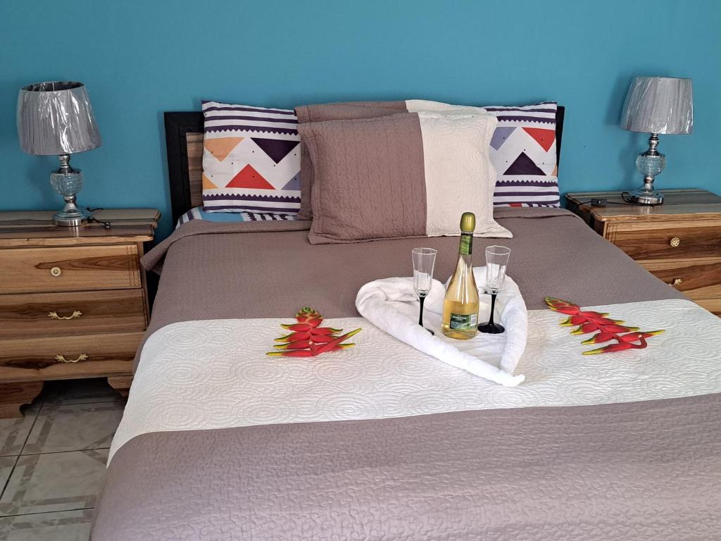 a bed with a bottle of champagne and two glasses at Villa Vista in Steer Town