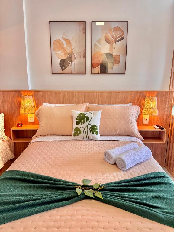 a bedroom with a bed with a green bow on it at Aurora Studio no Centro in Barbacena