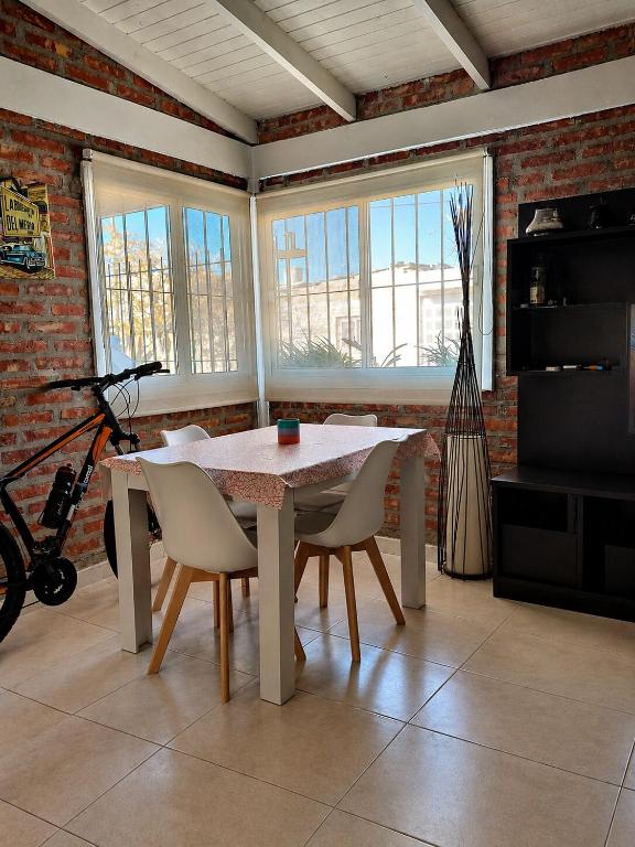 a dining room with a table and chairs and windows at Casa cálida y confortable en Allen in Allen