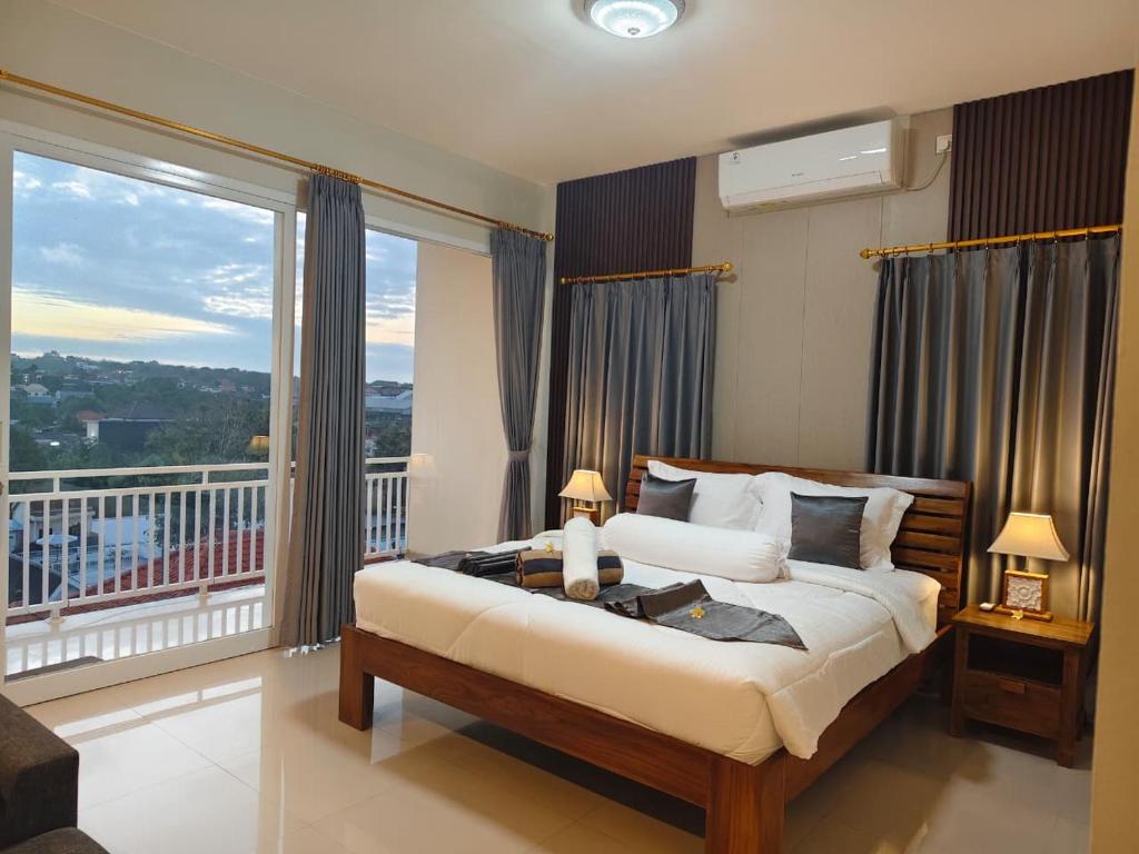 a bedroom with a large bed and a balcony at Sarining 2BR Villa With Pool in Uluwatu
