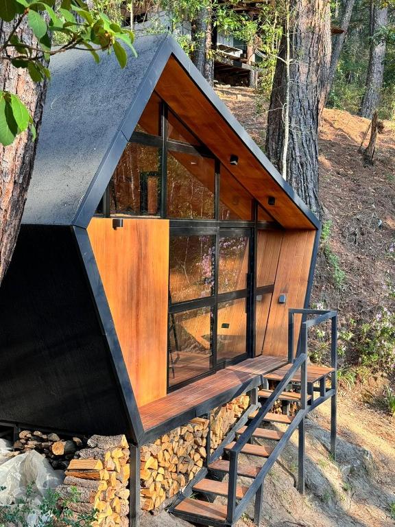 a small tree house with a bench in the woods at En medio de la nada in Mazamitla