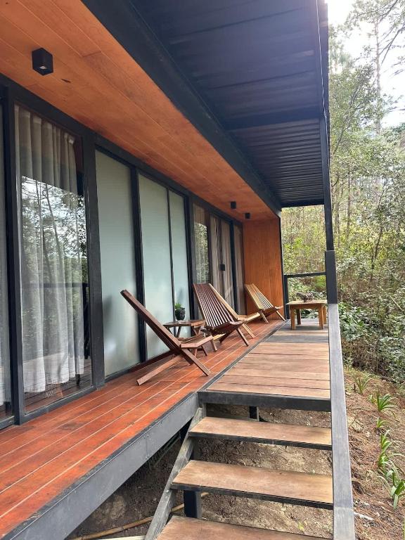 a porch of a house with two chairs on it at Disfruta del Bosque in Mazamitla