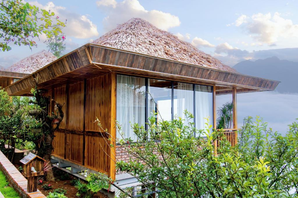 a small house with glass windows and a roof at Sapa Rose Garden Resort in Sapa