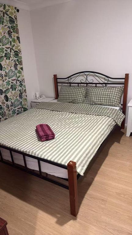 a bed with a wooden frame and a red towel on it at Room 1 Bright Spacious Room Walk to Shops in Kelmscott