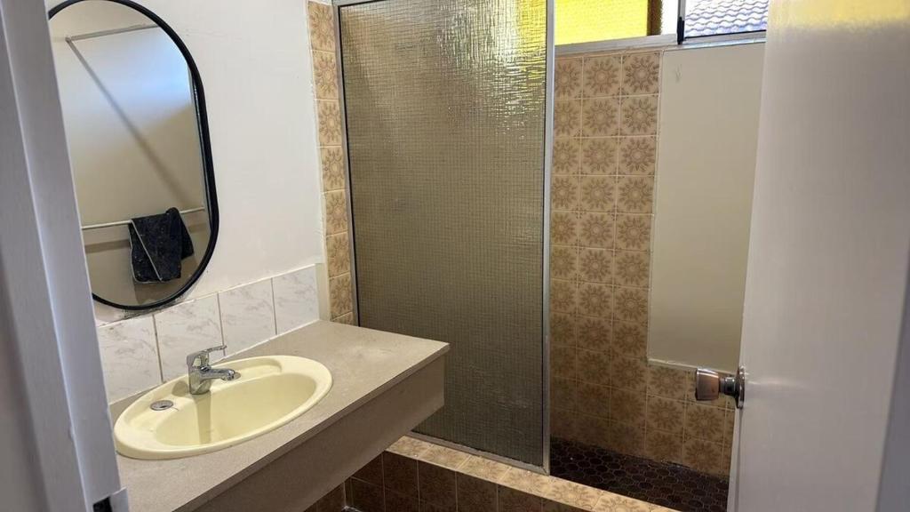a bathroom with a sink and a glass shower at Room 2 Bright Spacious Room Walk to Shops in Kelmscott