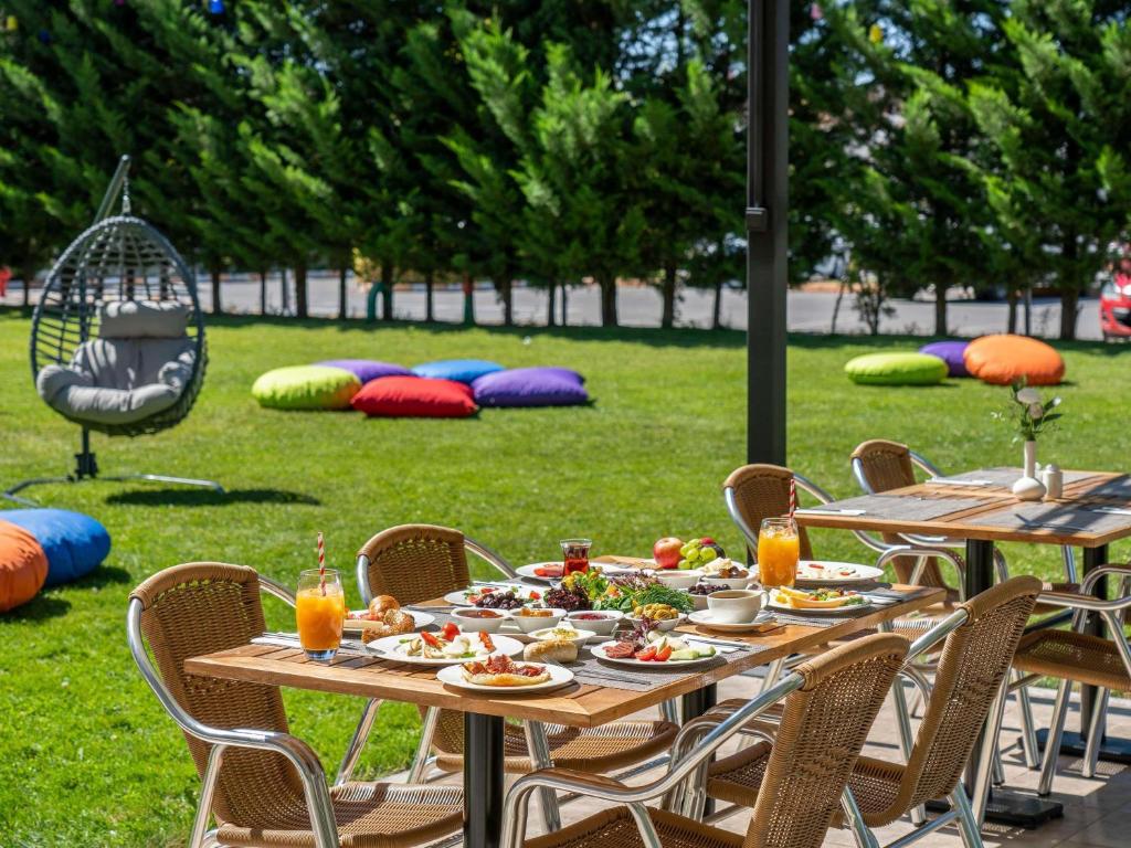 a table with plates of food on it in a park at Ibis Kayseri in Kayseri