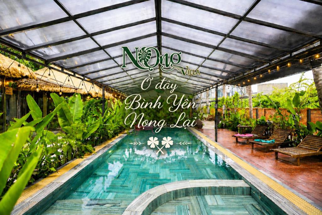 a swimming pool with a sign that reads i day build your moving law at Nọng Villa in Phan Thiet