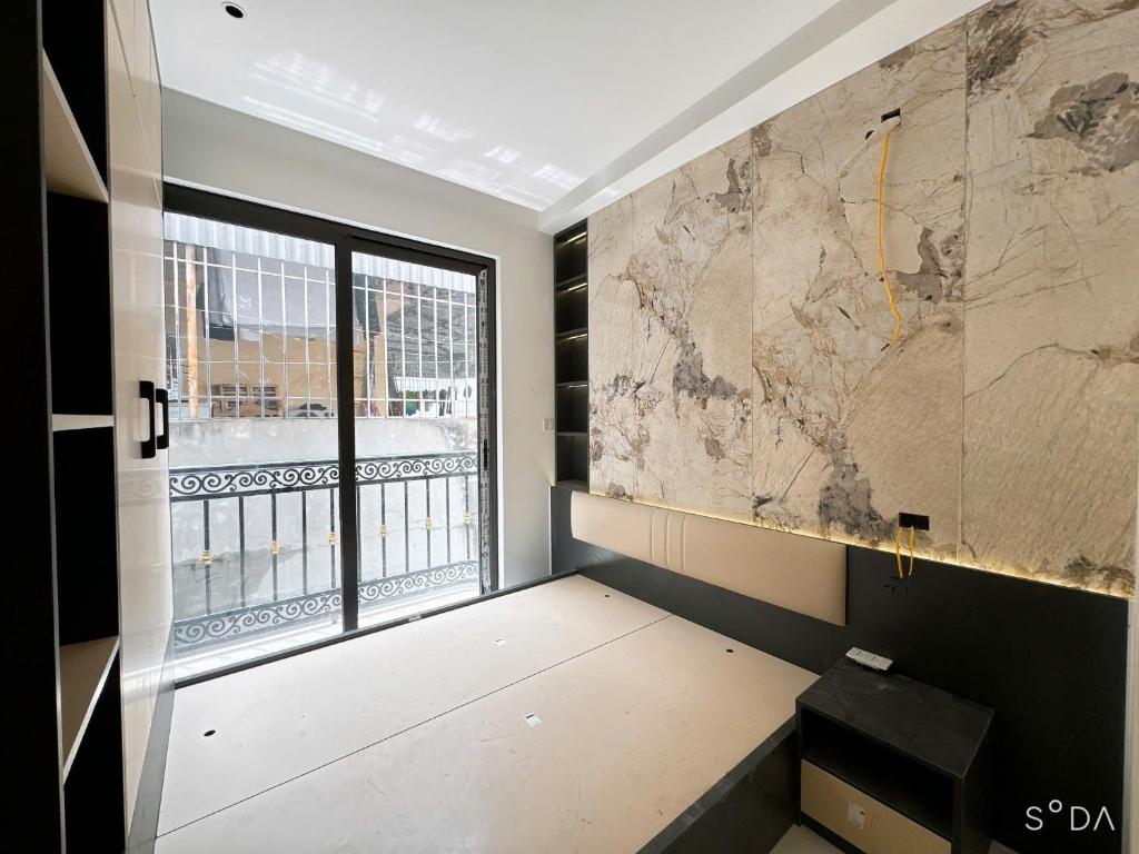 a room with a window and a large wall at Sunshine Housse with Balcony in Centre in Ho Chi Minh City