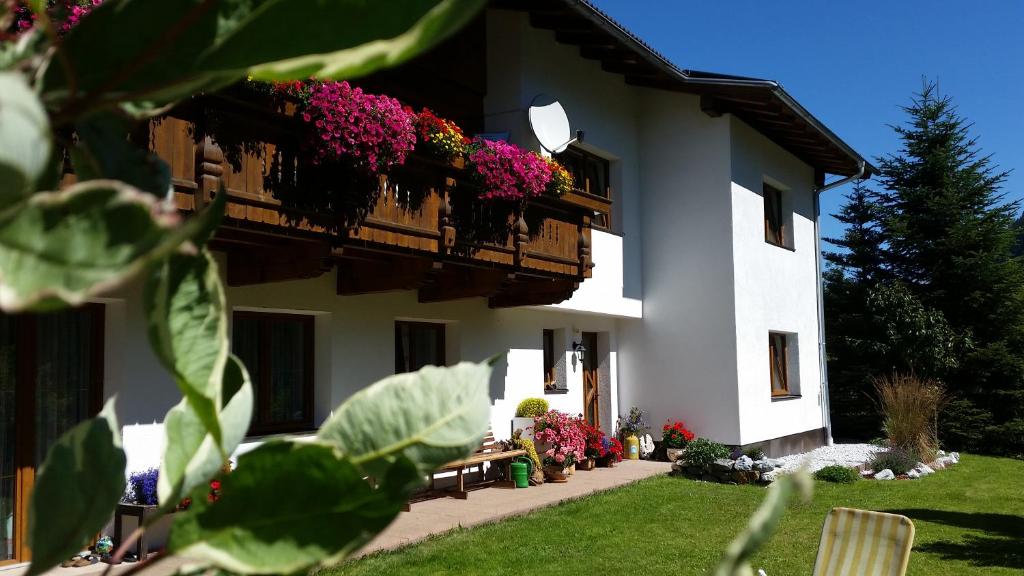 a building with a balcony with flowers on it at Haus Gletscherblick in Neustift im Stubaital