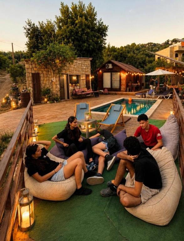 a group of people sitting on bean chairs near a pool at Rickystone in Jiwār al Bawāshiq