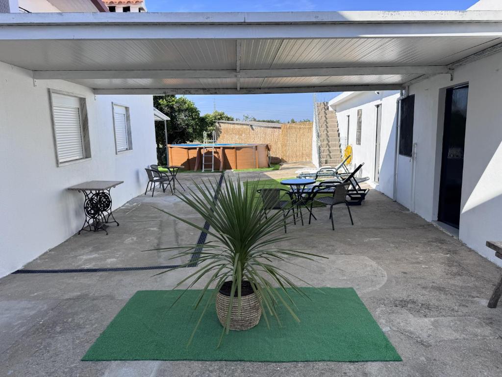a patio with a table and chairs and a plant at Refúgio Templário in Pedreira