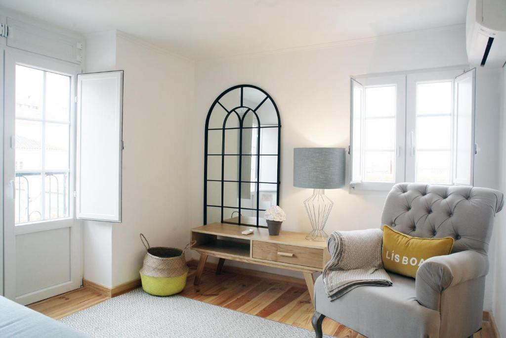 een woonkamer met een stoel en een spiegel bij Alfama Apartment with River view in Lissabon
