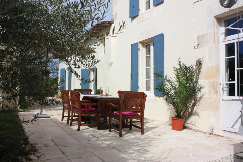 uma mesa e cadeiras num pátio em frente a um edifício em Le Chai O Soleils em Mortagne-sur-Gironde