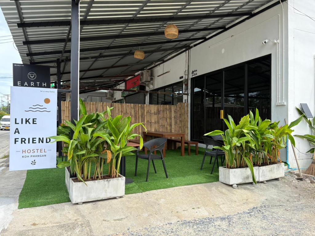 a restaurant with plants in front of a building at Like A Friend Hostel in Thong Sala