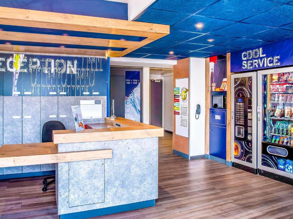 a bar in a soda shop with a soda machine at ibis budget Issoire in Issoire