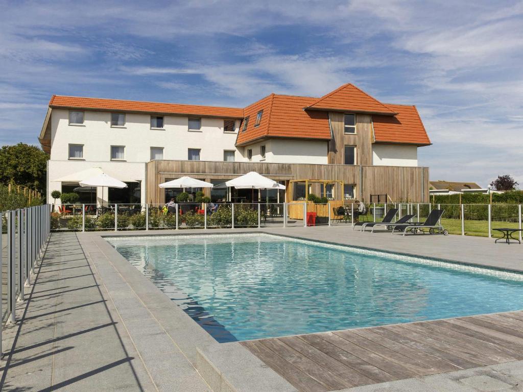 a swimming pool in front of a building at ibis De Haan in De Haan