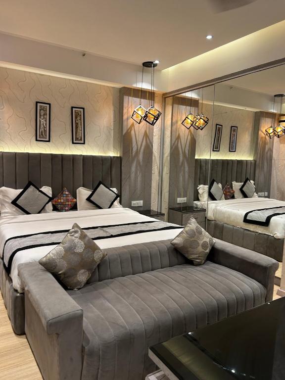 a large bedroom with two beds and a couch at The Origin Suites opposite Hyatt Dlf my pad Lucknow in Lucknow