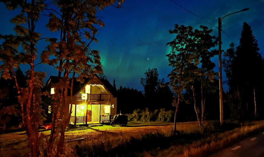 a house with a green light in front of it at Lapland Snow Cabin in Masugnsbyn
