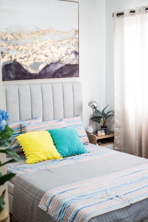 a bed with colorful pillows in a bedroom at The Nook at Park in Ibaba