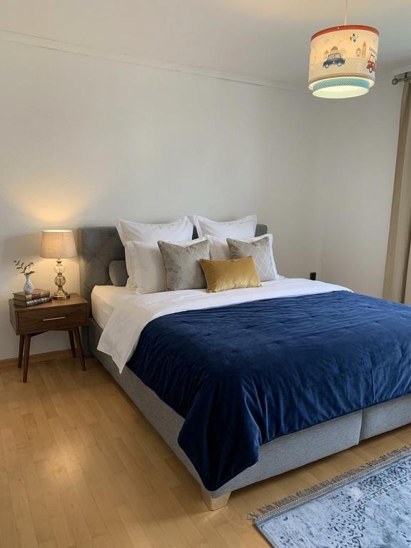 a bedroom with a large bed with blue sheets and pillows at Haus Tun in Gummersbach