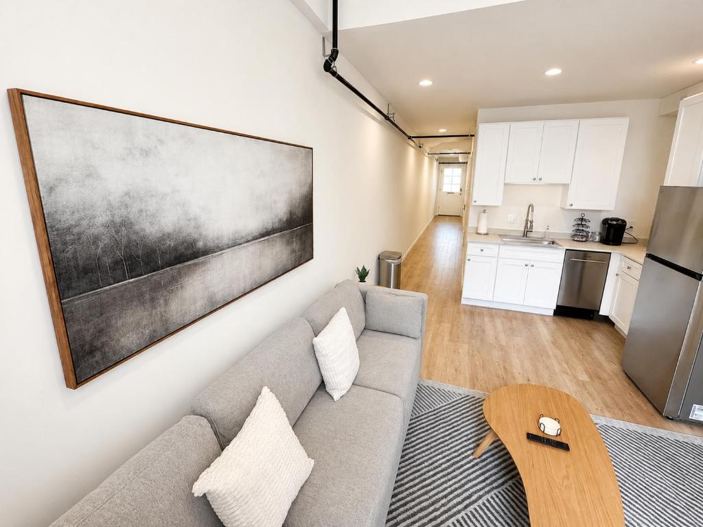 a living room with a couch and a kitchen at The Oak & Aura Retreat in St. Charles