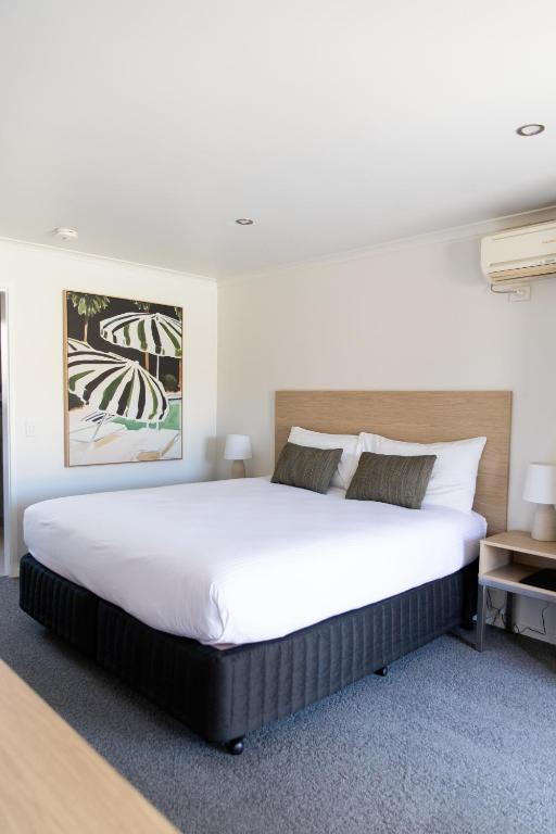 a bedroom with a large white bed in a room at Tea House Motor Inn in Bendigo