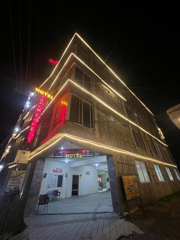 a building with lights on top of it at night at Black Forest Hotel in Kalām