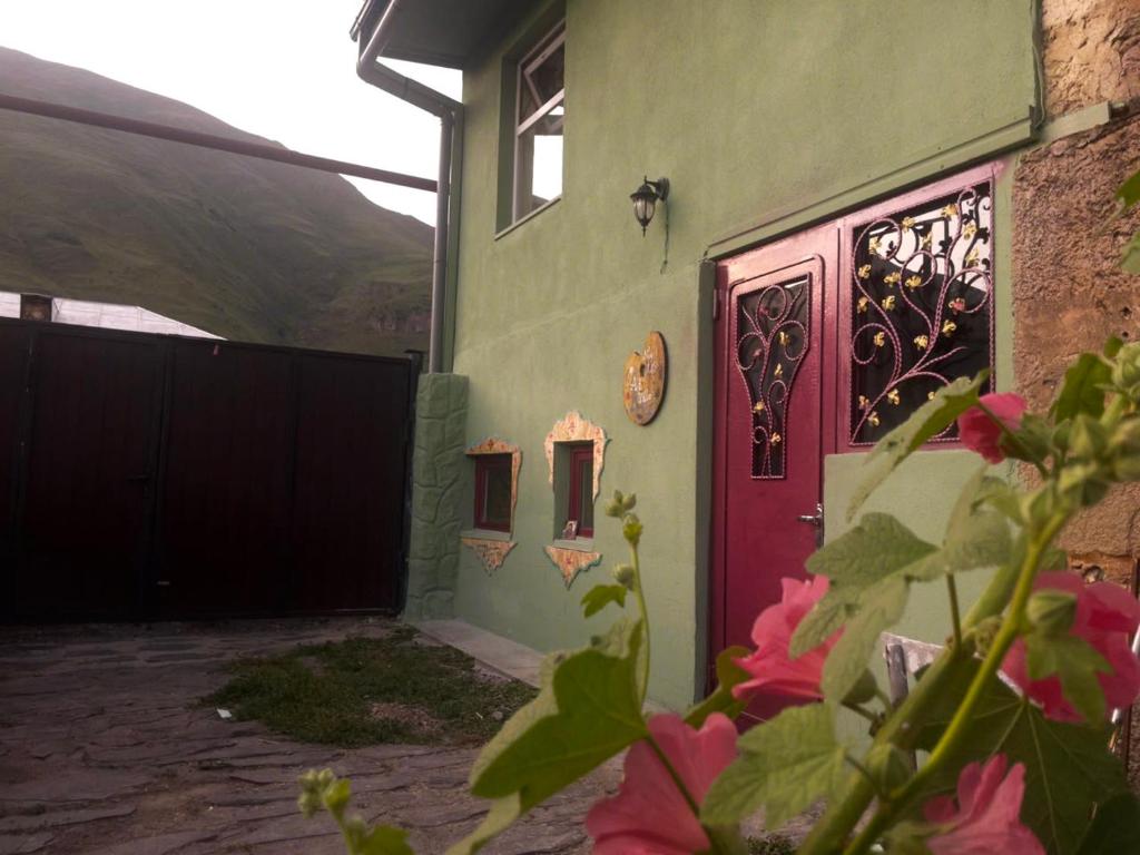 a house with a red door and a gate at Art Vila Galeri in Kazbegi