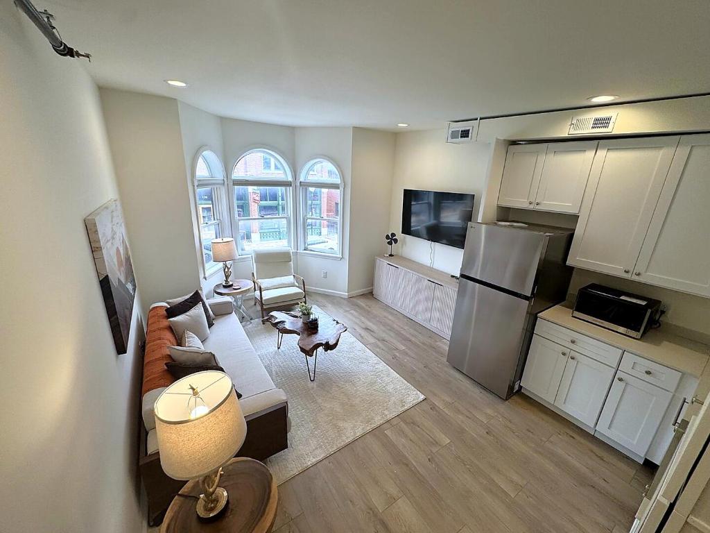 a living room with a couch and a kitchen at The Rustic Revival - Charming 2BR Retreat in St. Charles
