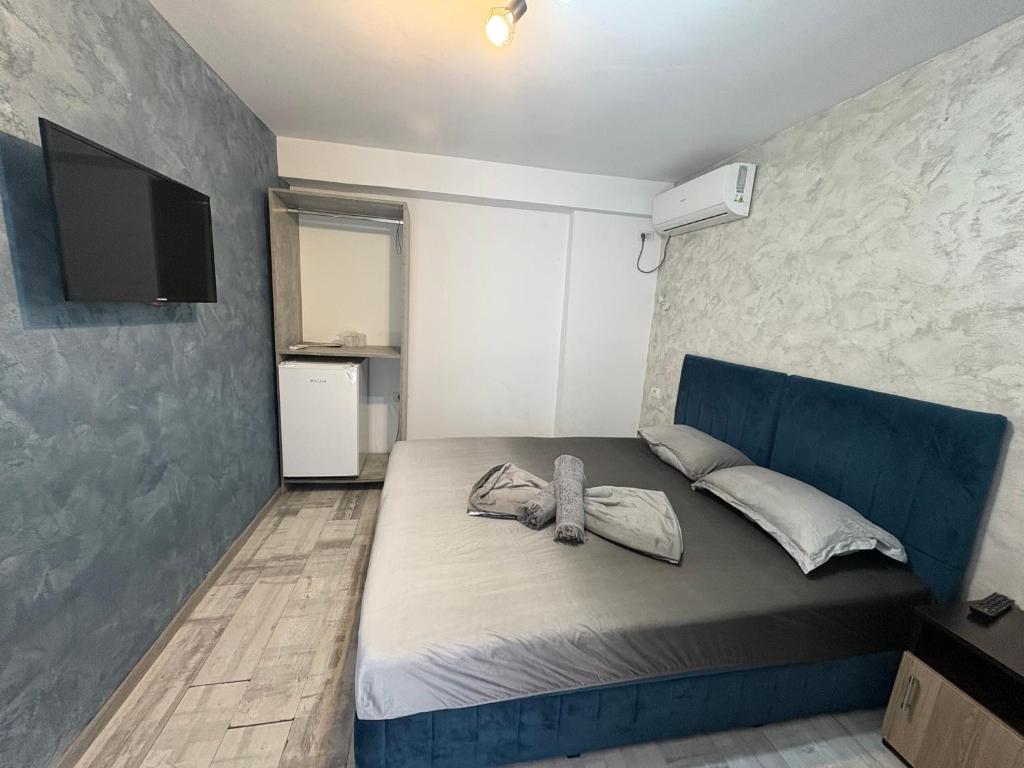 a bedroom with a blue bed with a tv on the wall at Ana L2 in Constanţa
