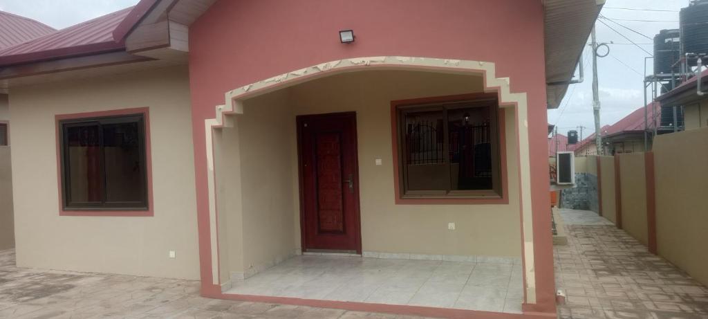 a pink building with an archway and a door at Axiom Services in Katamanso