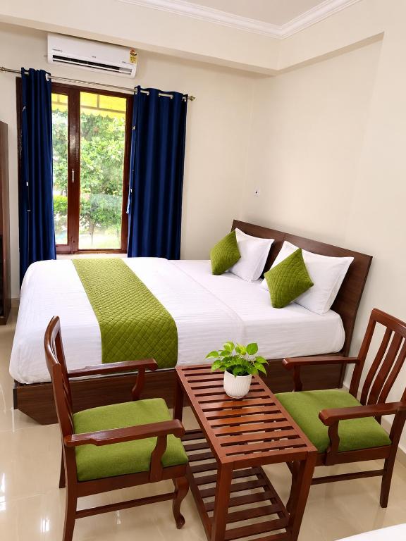 a bedroom with a bed and a table and chairs at Beach Resort in 1 in North goa