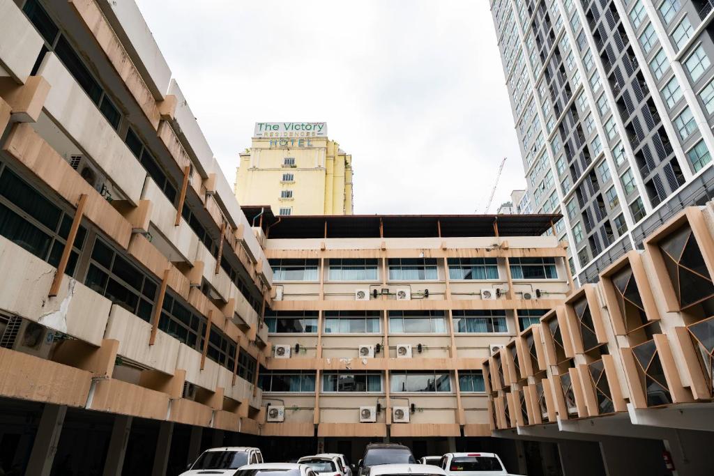 a parking lot in the middle of two tall buildings at Krungthai Hotel at Rangnam in Sathani Sam Sen
