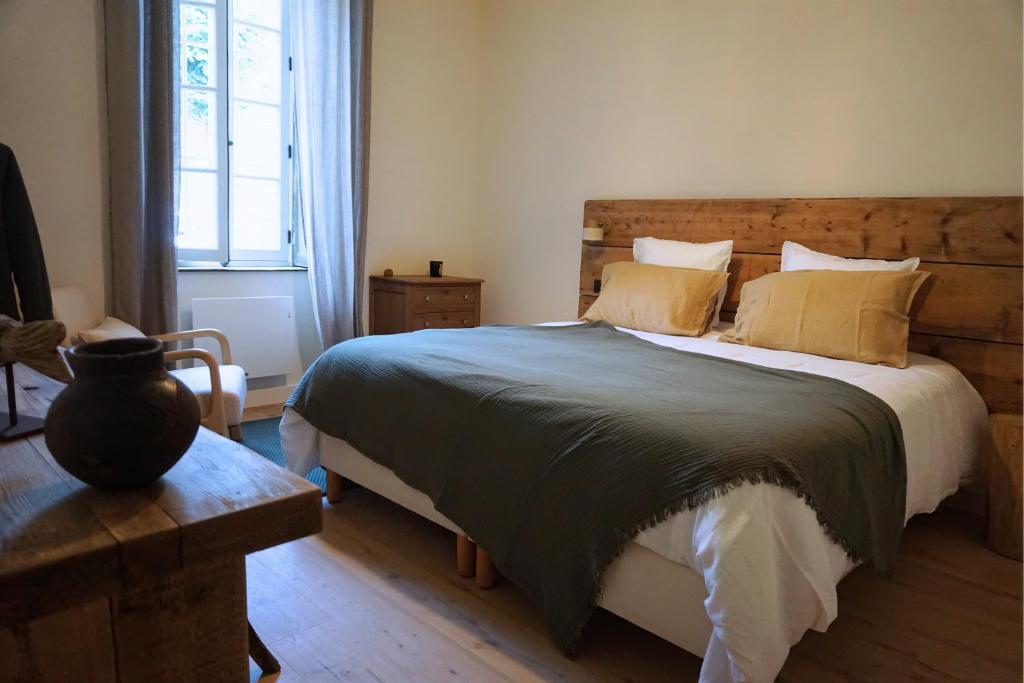 a bedroom with a large bed with a wooden headboard at Maison Constant - L'Erable in Autun