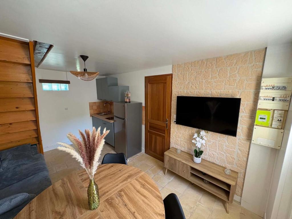 a living room with a table and a tv at Une pause Altifontaine in Hautefontaine