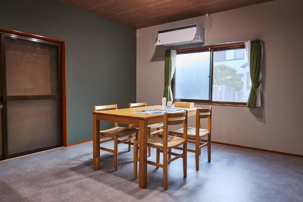 a dining room with a table and chairs and a window at Wan Kumano by WhyKumano in Nachikatsuura