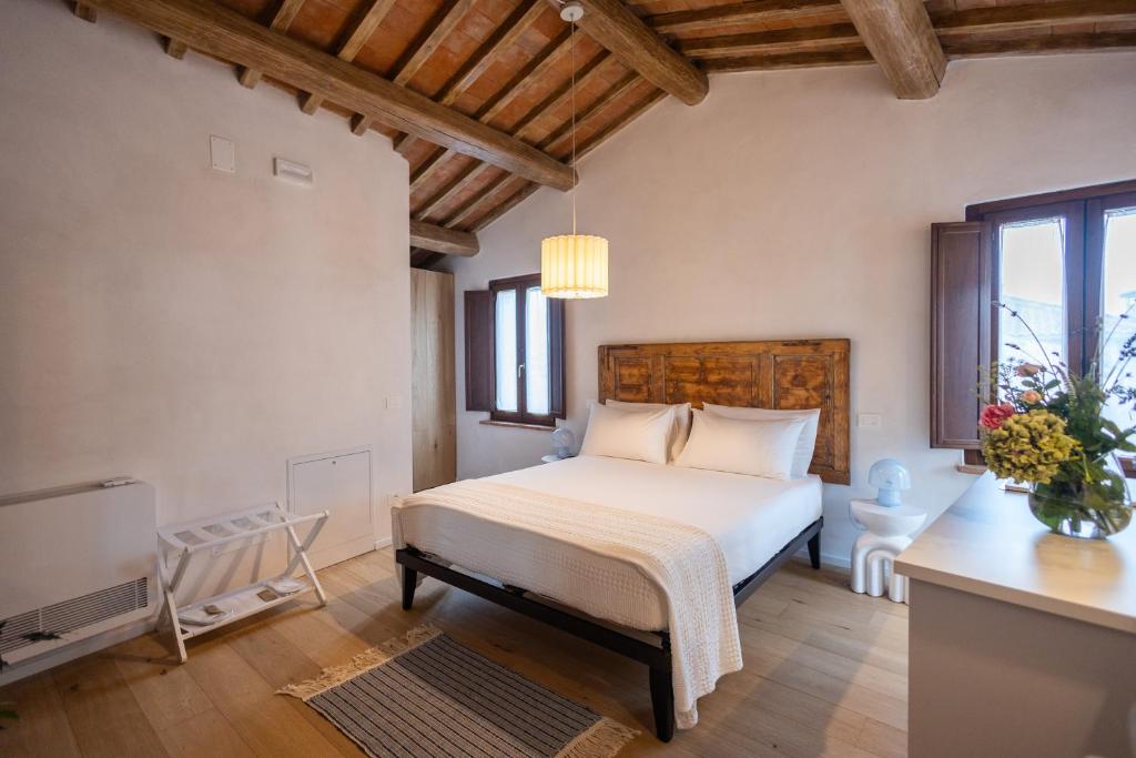 a bedroom with a white bed and a television at La casina del borgo - Monolocale Nettuno in Perugia