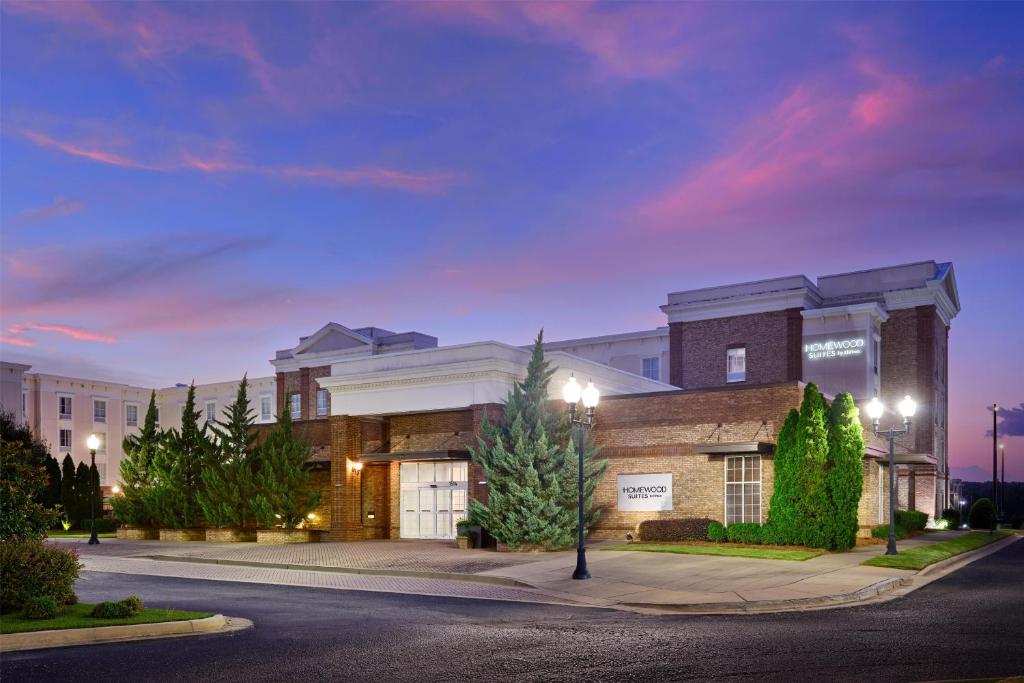 a building on a street with a purple sky at Homewood Suites by Hilton Macon-North in Wesleyan Hills