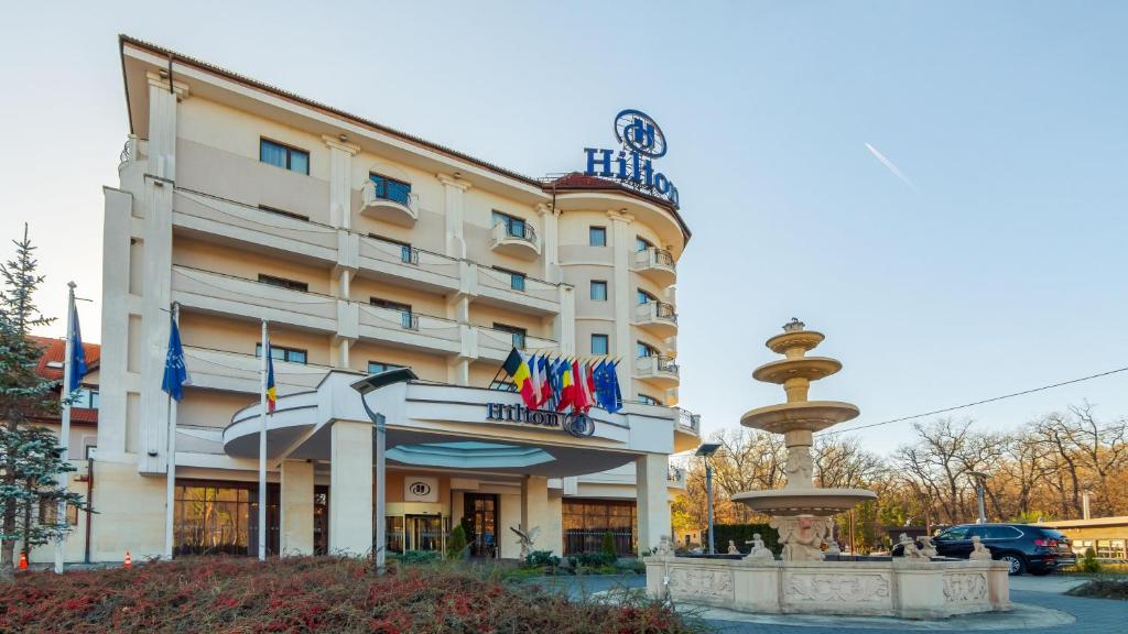 a hotel building with flags in front of it at Hilton Sibiu in Sibiu