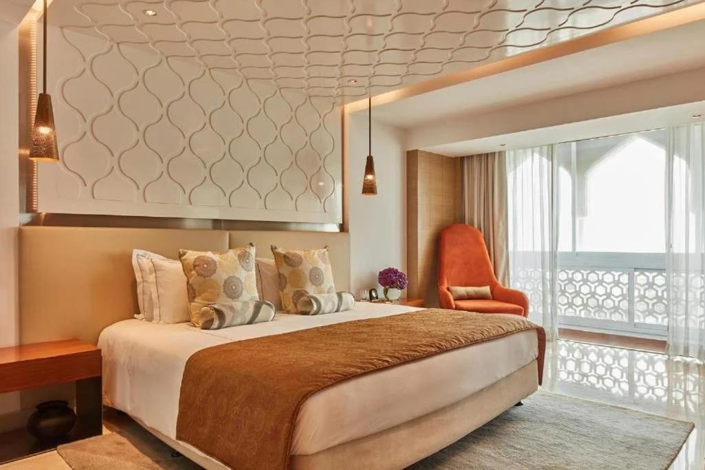 a bedroom with a bed and a chair and a window at Hotel Donland in Gwalior