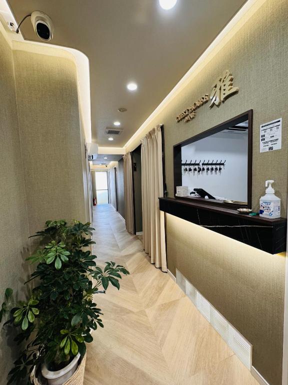 a hallway of a hospital with a television and plants at Guest house雅 in Matsudo