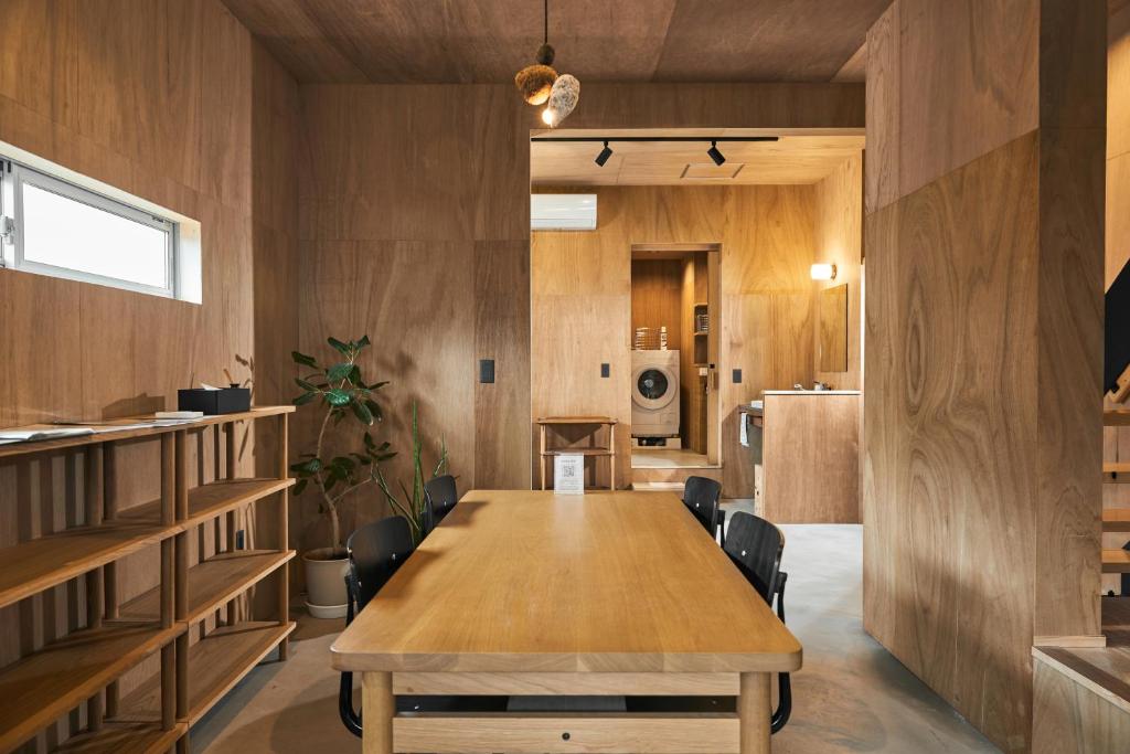 a dining room with a wooden table and chairs at Nem Kumano by WhyKumano in Nachikatsuura